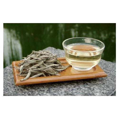 Белый чай в пиале и сухие почки рядом